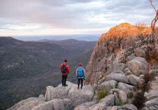 two hikers standing on top of Booroomba Rocks