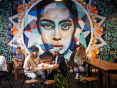 people dining near a vibrant wall art in Adelaide Central Market
