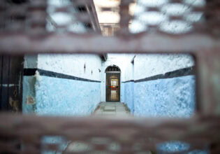 peeking through a small hole in the corridor of Fremantle Prison