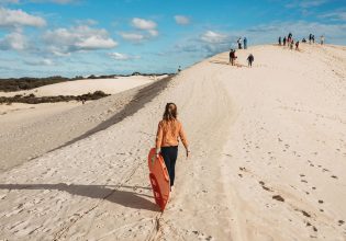 Girl carrying bodyboard at Little Sahara adventure centre