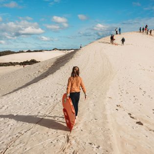 Girl carrying bodyboard at Little Sahara adventure centre