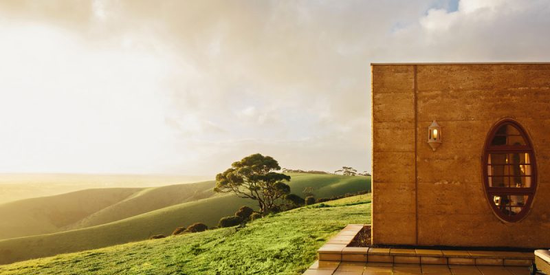 The Sky House on Kangaroo Island, atop a grassy hill with sun shining.