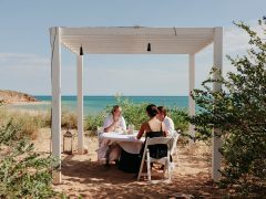 friends dining on the beachfront of Eco Beach Resort