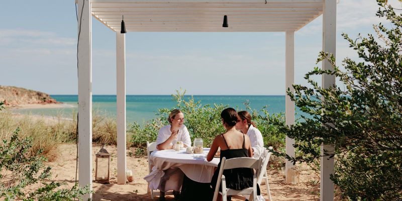 friends dining on the beachfront of Eco Beach Resort
