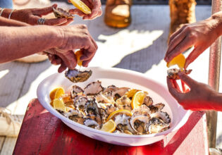Patrons enjoying oysters onboard Captain Sponge’s Magical Oyster Tour
