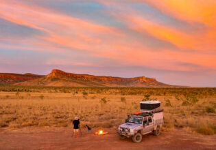 a man standing with a bonfire setup at sunset, the Kimberly and Gibb River Road trip