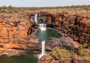 Two people standing at Mitchell Falls in the Kimberley (Image: Tourism Australia)