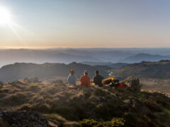Three people oat the summit of Ramshead Hike in Kosciuszko National Park