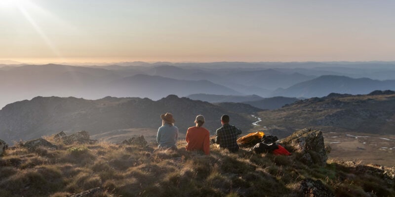 Three people oat the summit of Ramshead Hike in Kosciuszko National Park