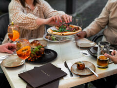 a group of people eating pizza with Aperol spritz at Vine & Tap Wine Bar, Bathurst