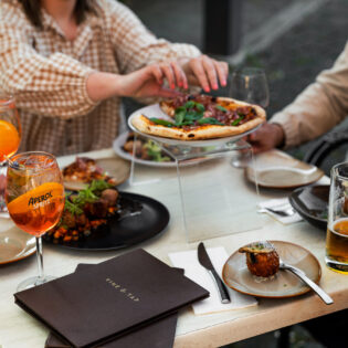 a group of people eating pizza with Aperol spritz at Vine & Tap Wine Bar, Bathurst