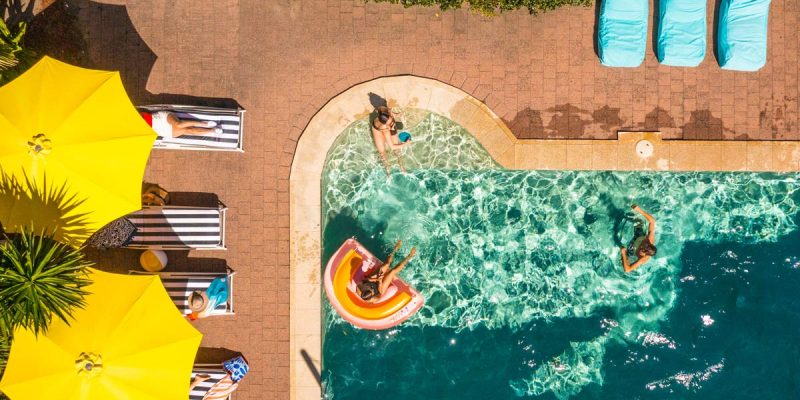 an overhead shot of people swimming in the pool at YHA Byron Bay